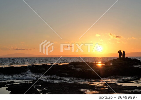 海に沈む夕日を眺める観光客 海に沈む夕日を眺める観光客 86499897