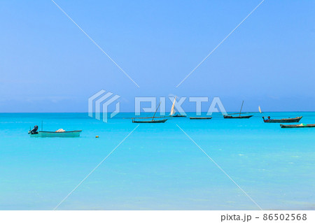 View of tropical sandy Nungwi beach and traditional wooden dhow boats in the Indian ocean on Zanzibar, Tanzania 86502568