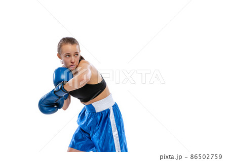 In action, motion. Young girl, professional boxer practicing in boxing gloves isolated on white studio background. Concept of sport, studying, competition 86502759