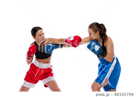 Two woman professional boxers boxing isolated on white studio background. Couple of fit muscular caucasian athletes fighting. Sport, competition Two woman professional boxers boxing isolated on white studio background. Couple of fit muscular caucasian athletes fighting. Sport, competition 86502799