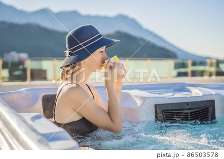 Portrait of young carefree happy smiling woman relaxing at hot tub during enjoying happy traveling moment vacation life against the background of green big mountains 86503578
