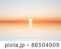 Sun on horizon of water with waves on blue sky 86504009