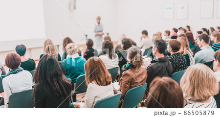 Female speaker giving a talk at business meeting. Audience in conference hall. Business and entrepreneurship symposium. Female speaker giving a talk at business meeting. Audience in conference hall. Business and entrepreneurship symposium. 86505879