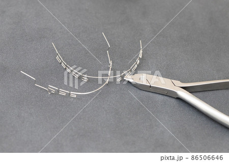 drawing up a multiloop ortho-arc on a gray background in a special tool. dentistry, beautiful smile 86506646