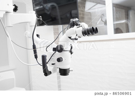 Dental microscope with video camera. against the background of modern dentistry. Medical equipment. operating microscope. with swivel double binoculars. dental microscope. an office in a white office 86506901