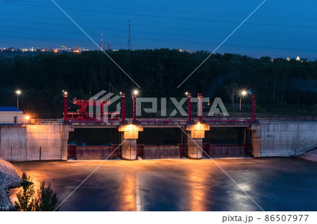 River,dam,bridge in the evening.Car and pedestrian bridge at night. A full-flowing river with a strong current.Clean,bubbling,fresh water.Technical construction on the river, fresh water reserves. River,dam,bridge in the evening.Car and pedestrian bridge at night. A full-flowing river with a strong current.Clean,bubbling,fresh water.Technical construction on the river, fresh water reserves. 86507977