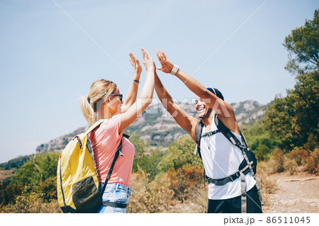 Cheerful backpackers meeting for hiking together in sunny day 86511045