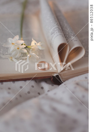 Wedding golden ring and open book with folded sheets in heart shape. Wedding concept, Valentines Day Wedding golden ring and open book with folded sheets in heart shape. Wedding concept, Valentines Day 86512038