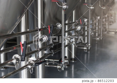 Modern Beer Factory. Steel tanks for beer fermentation and storage. Brewery. Modern beer plant with brewering kettles Modern Beer Factory. Steel tanks for beer fermentation and storage. Brewery. Modern beer plant with brewering kettles 86512203