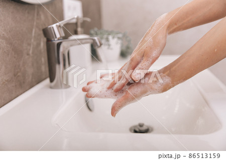 Washing hands under the flowing water tap. Hygiene concept hand detail. Washing hands rubbing with soap for corona virus prevention, hygiene to stop spreading corona virus in or public wash room. Washing hands under the flowing water tap. Hygiene concept hand detail. Washing hands rubbing with soap for corona virus prevention, hygiene to stop spreading corona virus in or public wash room. 86513159