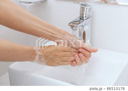 Washing hands under the flowing water tap. Hygiene concept hand detail. Washing hands rubbing with soap for corona virus prevention, hygiene to stop spreading corona virus in or public wash room. Washing hands under the flowing water tap. Hygiene concept hand detail. Washing hands rubbing with soap for corona virus prevention, hygiene to stop spreading corona virus in or public wash room. 86513176