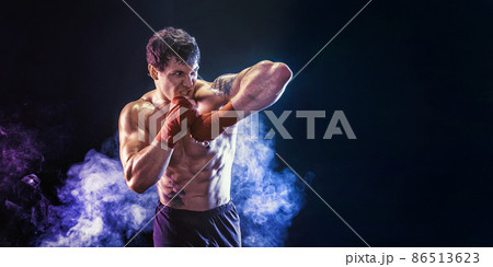 Kickboxer delivering an elbow hit isolated on smoke background. Sport concept, mixed martial arts 86513623