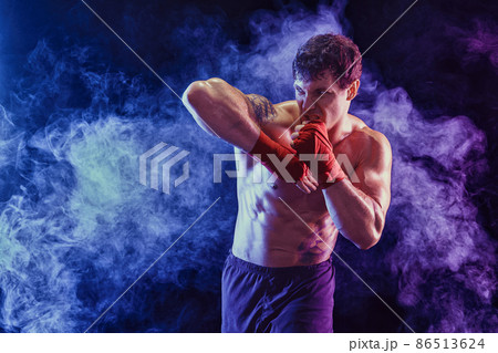 Kickboxer delivering elbow hit isolated on smoke background. Concept of sport, mixed martial arts.  86513624