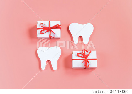 Happy dentist day. Paper cut mockup of tooth and gift boxes on pink background. Dental care concept. Greeting card. Copy space. Happy dentist day. Paper cut mockup of tooth and gift boxes on pink background. Dental care concept. Greeting card. Copy space. 86513860