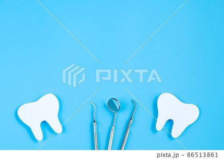 Happy International Dentist Day. Paper cut mockup of tooth and dental tool on blue background. Dental care concept. Greeting card for professional holiday. Copy space. 86513861