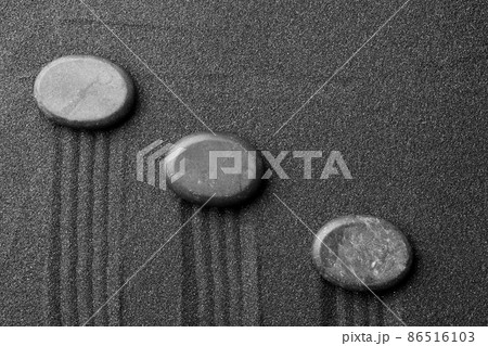 Zen garden stones on black sand with pattern, top view Zen garden stones on black sand with pattern, top view 86516103