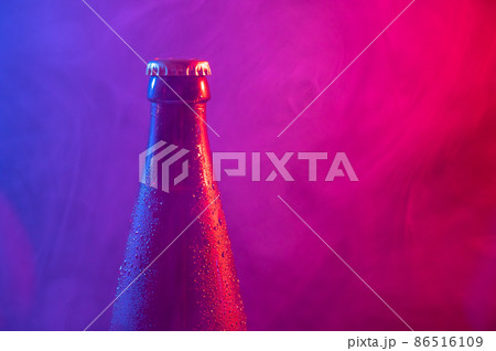 Glass bottle of beer in blue pink mist Glass bottle of beer in blue pink mist 86516109