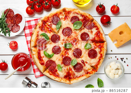 Flat lay composition with hot pepperoni pizza on white wooden table Flat lay composition with hot pepperoni pizza on white wooden table 86516287