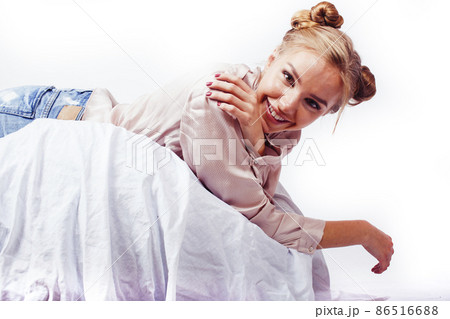 young pretty blond woman laying in bed isolated on white background, lifestyle people concept 86516688