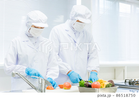 クリーンスーツで野菜のカットをする男女（食品加工） 86518750