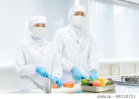 クリーンスーツで野菜のカットをする男女（食品加工） 86518751