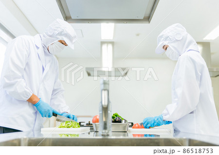 クリーンスーツで野菜のカットをする男女（食品加工） 86518753
