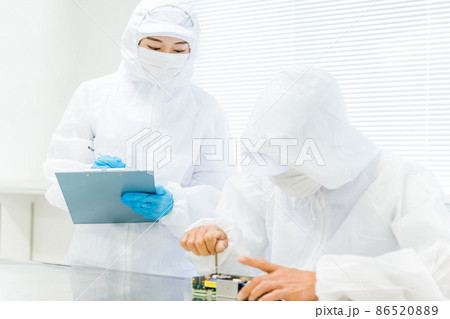 クリーンルームで精密機器を扱う男性と検査する女性 クリーンルームで精密機器を扱う男性と検査する女性 86520889