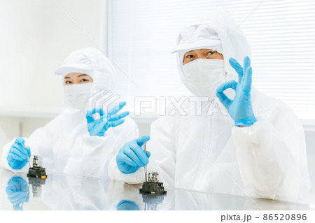 精密機器の組み立てをする男女 86520896