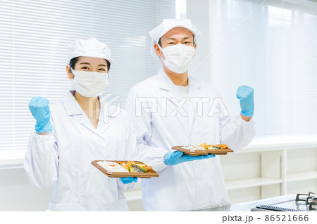 お弁当の盛り付けをする男女（食品加工・手袋） 86521666