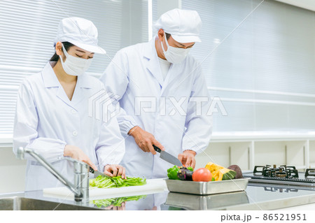 食品工場・スーパーで働く男女（マスク） 86521951