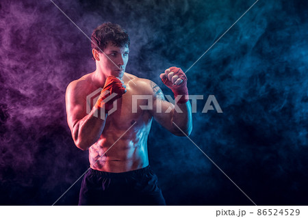 Half length of shirtless boxer fighter who preparing for fight on smoke background. Sport concept Half length of shirtless boxer fighter who preparing for fight on smoke background. Sport concept 86524529