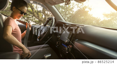 Female driver buckle up the seat belt before driving car Female driver buckle up the seat belt before driving car 86525214