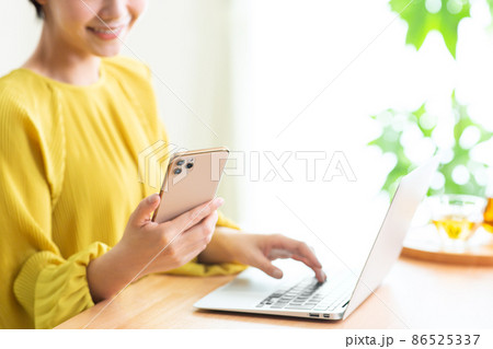 リビングでパソコンとスマホをする女性 スマホ パソコン リビング パーツカット ライフスタイル リビングでパソコンとスマホをする女性 スマホ パソコン リビング パーツカット ライフスタイル 86525337
