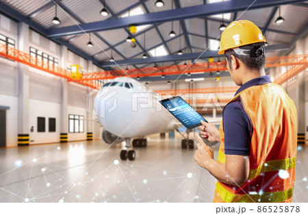 Asian engineer or technician with airplane in hangar 86525878