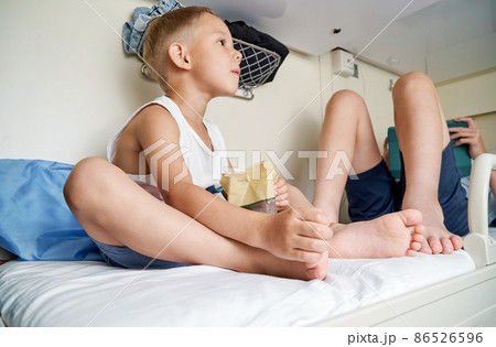 Brothers rest on top shelf in train car and play on tablet 86526596