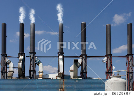 Smoky chimneys with a blue sky background. Smoky chimneys with a blue sky background. 86529397