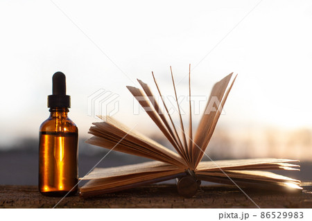 Alternative medicine - open old book and bottles. 86529983