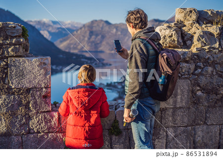 Dad and son travelers in Montenegro in Kotor Old Town Ladder of Kotor Fortress Hiking Trail. Aerial drone view 86531894
