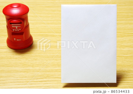 木目の机に置いた郵便ポスト形の貯金箱と郵便封筒(コピースペース有り) 木目の机に置いた郵便ポスト形の貯金箱と郵便封筒(コピースペース有り) 86534433