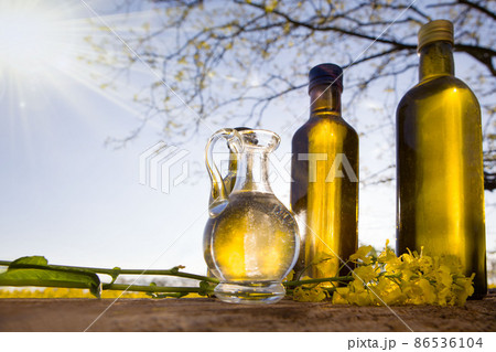 Rapeseed oil set bottles (canola) on background rape field. 86536104