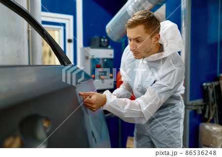 Painter examining car body paint check process Painter examining car body paint check process 86536248