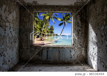 View of a sea beach with palms trees, through a window hole in a abandoned panel house. View of a sea beach with palms trees, through a window hole in a abandoned panel house. 86536404