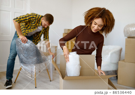 Happy couple packing beginnings before home moving 86536440