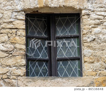 A window with decorative glass in the facade of a historic building. A window with decorative glass in the facade of a historic building. 86536648