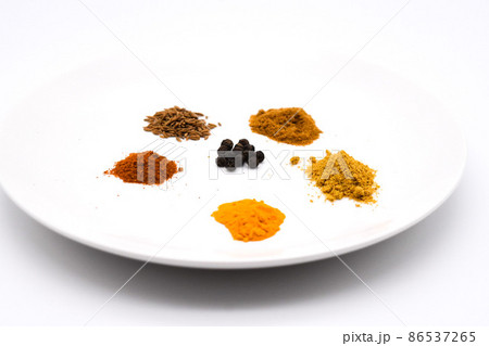 お皿に盛られた色んな種類のスパイスセット 86537265