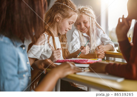 Girl holding pencil and drawing in a notebook 86539265