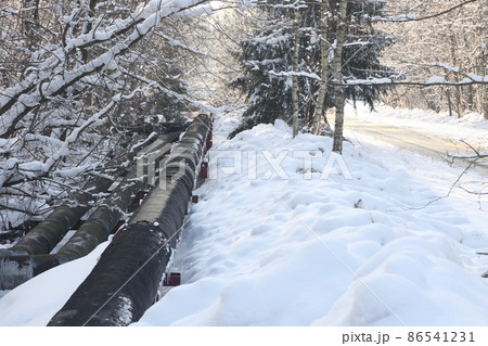 The main provides the city with hot water. Selective focus. The large pipes of the central heating system are covered with snow. Icicles on pipes. fuel crisis. Increasing the cost of heating. 86541231