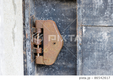 古い倉庫の入り口に取り付けられた錆びた錠 86542617