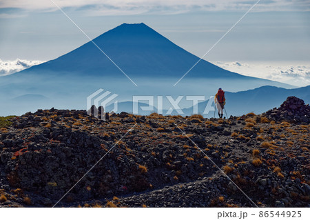 南アルプス・間ノ岳山頂付近を行く登山者と富士山 86544925