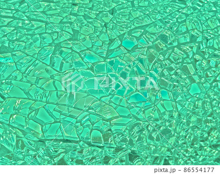 エメラルドグリーンやターコイズに光る細かくひび割れたガラスの鏡の背景画像 86554177